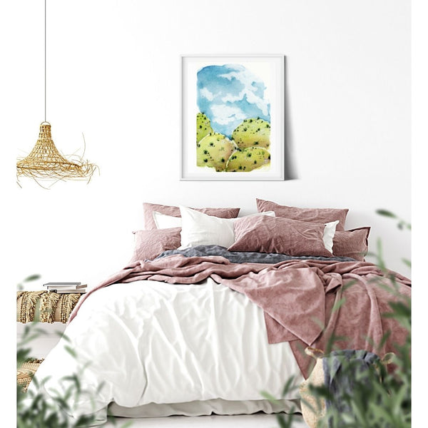 Blue sky stylized American Southwest blue and green Landscape watercolor canvas print. Visual art piece with bold, ethereal colors against a white wall. Print of a desert hill painting. Great for minimalist home decor. Exudes magical realism and playfulness. Emerald green grassy hills. Canvas print hanging on white walls in serene bedroom wall decor.