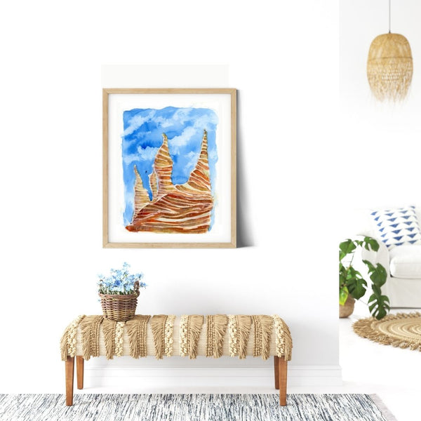 "Cathedral Rock" Trippy Sedona Red Rocks - Blue sky stylized American Southwest trippy painting watercolor canvas print. Visual art piece with bold, ethereal colors against a white wall. Print of a desert hill mountain landscape painting. Great for minimalist home decor, children’s room or colorless spaces. Exudes magical realism and playfulness. Canvas print hanging on white walls above a bench.Watercolor Canvas Print
