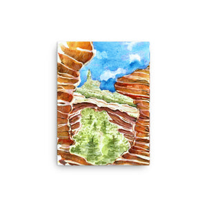12 by 16 inches Psychedelic Sedona Red Rocks Southwestern wall art watercolor Canvas Print. Stylized American Southwest watercolor canvas print. Visual art piece streaked with red stripes, softened with earthy greens pine trees and blue sky, against a white wall.  Archival print of original high desert watercolor painting of illustrator and artist Patricia Jacques. Punch of color for minimalist home decor. Exudes magical realism and playfulness.